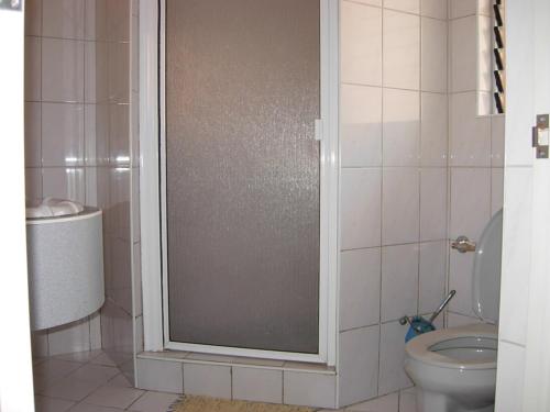 uma casa de banho com um WC e uma porta de duche em vidro. em Blue Coral Resort Boracay em Boracay