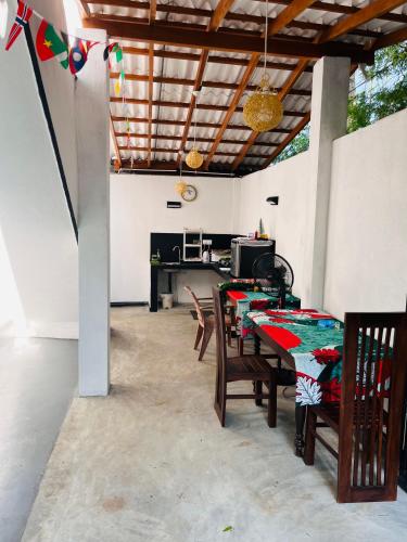 a patio with tables and chairs and a kitchen at Anthony Guesthouse in Hikkaduwa