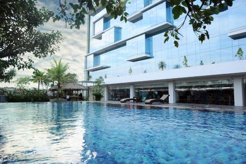 a swimming pool in front of a building at Hotel Santika Tasikmalaya in Tasikmalaya