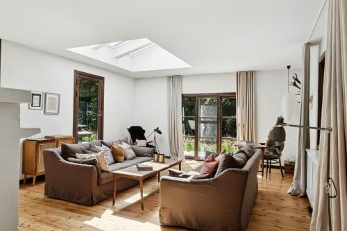 Una sala de estar con dos sofás y una mesa. en Architect Designed With Two Wings By Tisvilde Hegn, en Tisvildeleje