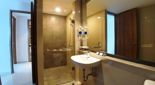un baño con lavabo y ducha en Wing Hotel Kualanamu Airport, en Kampungbesar