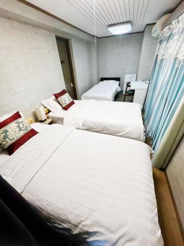 a room with three beds in it with at 烟雨轩301新 in Tokyo