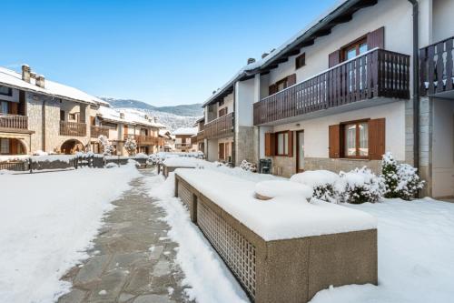 een met sneeuw bedekte straat met gebouwen bij Maison Dolce Vento - Happy Rentals in Oulx