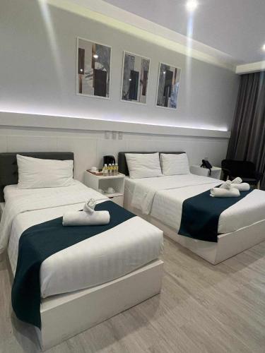 Un dormitorio con dos camas con toallas encima. en NOVADECI Suites, en Manila