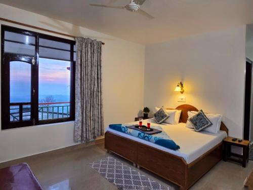 a bedroom with a bed and a large window at East Home Stay in Dharmsala