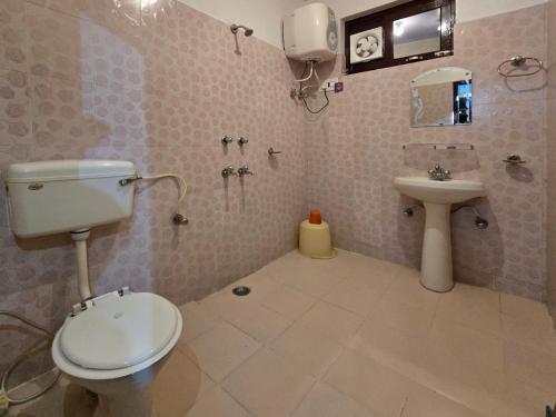 a bathroom with a toilet and a sink at East Home Stay in Dharmsala