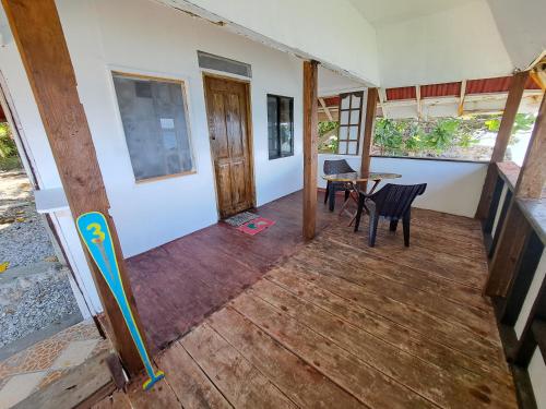 een veranda met een tafel en stoelen bij Paseo Del Mar Seaside Inn in Jagna