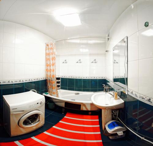 ハバロフスクにあるApartments on Sheronova 10 Orangeのバスルーム(バスタブ、シンク、洗濯機付)