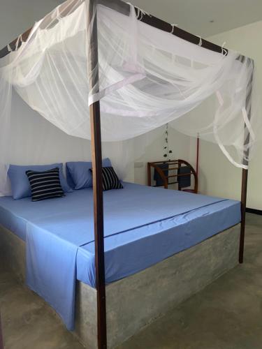 a bed with a canopy in a room at Relax Corner in Hiriketiya