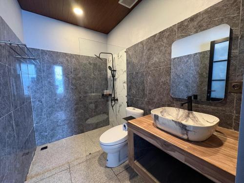 un bagno con lavandino, WC e doccia di Tera Bali Villa Bedugul 2 a Bedugul
