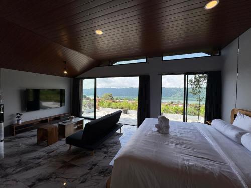 una camera da letto con un letto, un divano e una TV di Tera Bali Villa Bedugul 2 a Bedugul