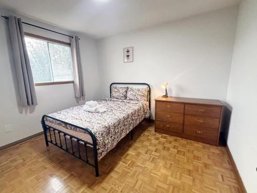 una camera da letto con un letto, un comò e una finestra di Relocation Ready- Pet-Friendly 4BR-Core of transit a Vaughan