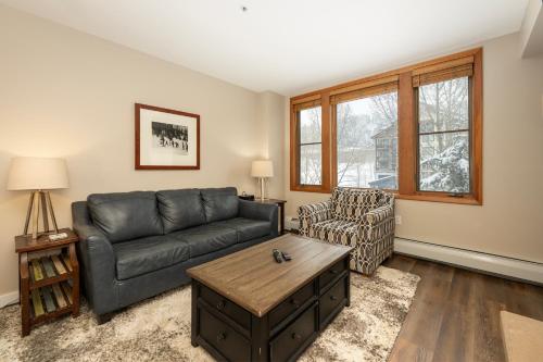 a living room with a leather couch and a coffee table at Ski-In/Ski-Out Zephyr 1 Bedroom Condo Winter Park in Winter Park