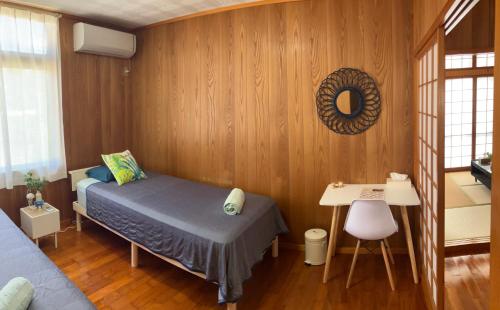 um quarto com uma cama e uma escrivaninha em Sunkissed Divers Okinawa Yomitan Guest House 1 em Yomitan