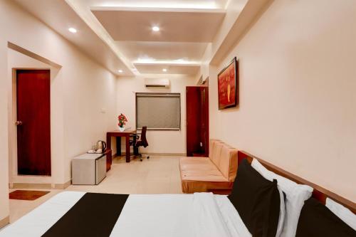 una habitación con una cama y una silla y una pantalla en Townhouse Oak Ramdaspeth Downtown, en Nagpur