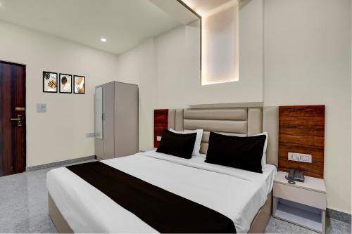 1 dormitorio con 1 cama blanca grande con almohadas negras en Townhouse Subharti University Meerut Formerly Hotel Celebration, en Panchli