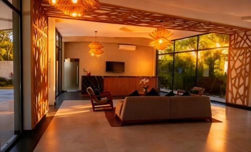 een woonkamer met een bank en een tv bij The Empire Amira in Tulum