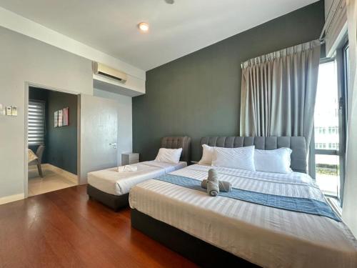 a bedroom with two beds with a teddy bear on it at IMAGO The Loft Kota Kinabalu City Centre by LW Suites in Kota Kinabalu