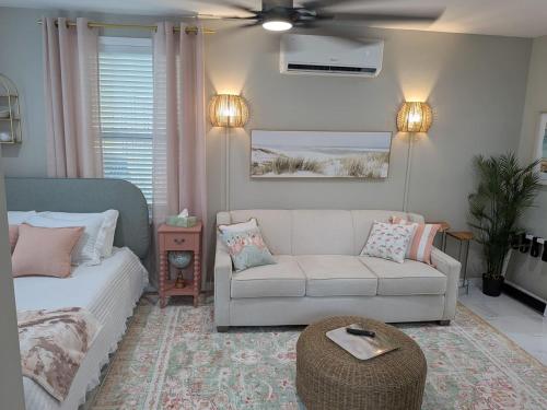 een woonkamer met een witte bank, een bank en een tafel bij Heavenly Hideaway in Holly Hill