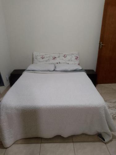 una camera da letto con un letto con copriletto bianco di Casa Petrópolis a Petrópolis