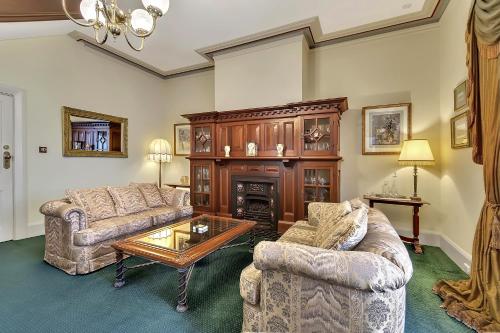 a living room with two couches and a fireplace at The Clifton Motel in Bunbury