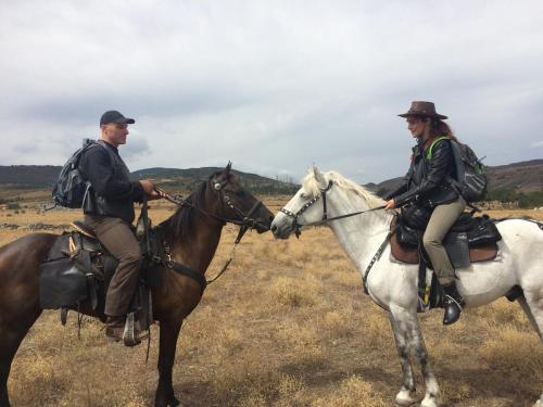two people riding on horses in a field at Alex's Cosy Guesthouse in Tbilisi City