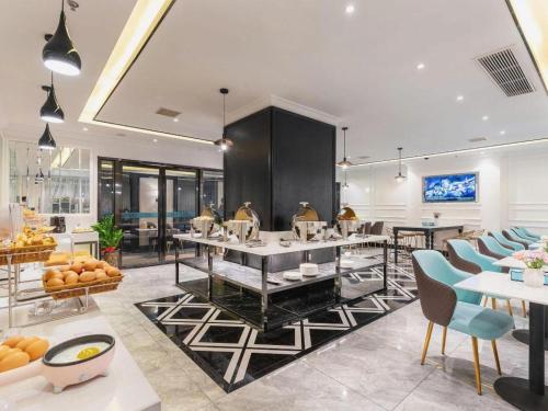 uma sala de jantar com mesas e cadeiras e uma cafeteria em Xana Hotelle Tianjin Binjiang Road Heping Road Metro Station Quanyechang em Tianjin