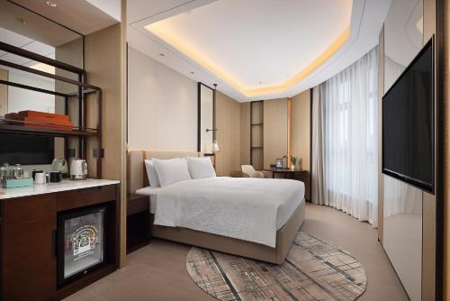 武漢市にあるWANDA YI Wuhanのベッドと暖炉のあるホテルの部屋