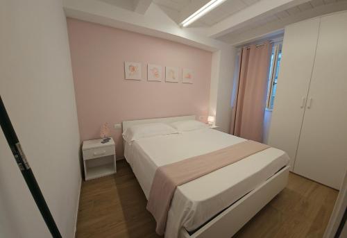 a white bedroom with a bed and a window at NALI Apartment 1 in Civitanova Marche