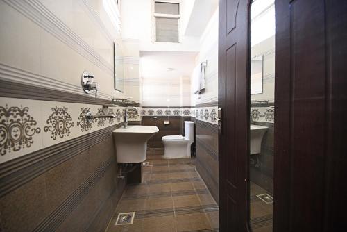 een badkamer met 2 wastafels en een toilet bij Hotel De Universal in Kathmandu