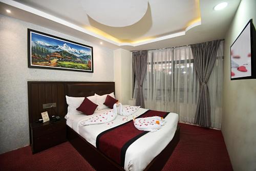 een hotelkamer met een bed met twee kussens bij Hotel De Universal in Kathmandu