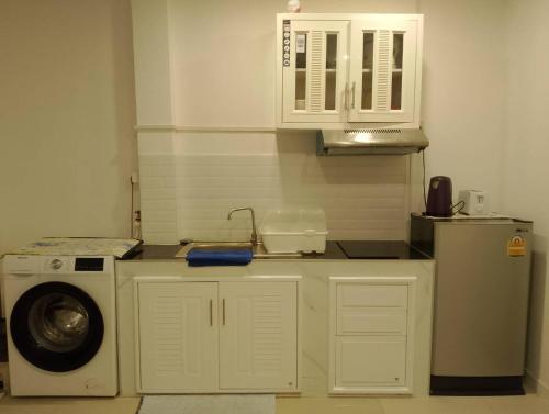 a kitchen with a washing machine and a microwave at AURA House in Pattaya South