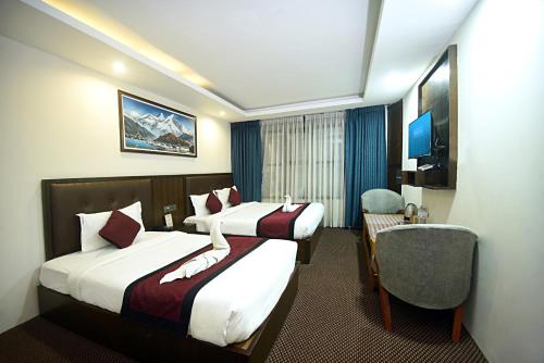 pokój hotelowy z dwoma łóżkami i krzesłem w obiekcie Hotel De Universal w Katmandu