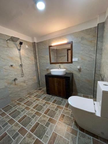 a bathroom with a sink and a toilet and a tub at Villa Amore in Ahangama
