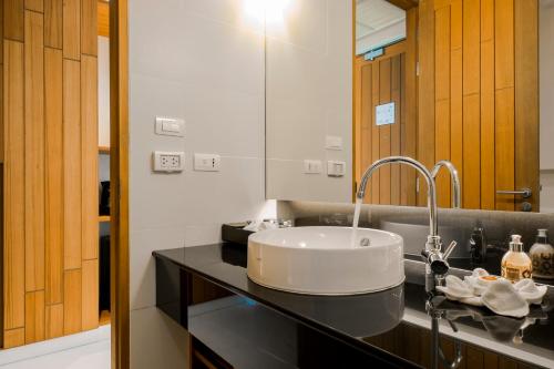 a bathroom with a sink and a mirror at G Hua Hin Resort & Mall - SHA Extra Plus in Hua Hin