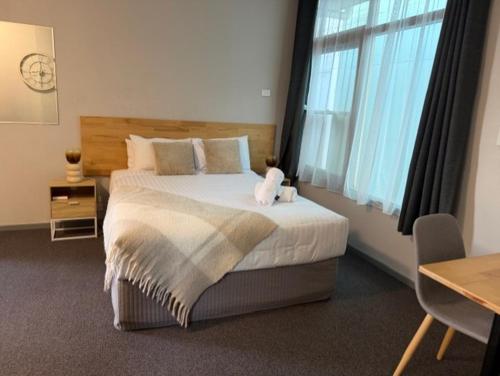 ein Schlafzimmer mit einem Bett, auf dem ein Teddybär liegt in der Unterkunft Dawson Motel in Lismore