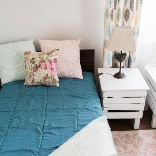 a bed with a blue comforter and pillows in a bedroom at Siedlisko Józefka in Zaróbka