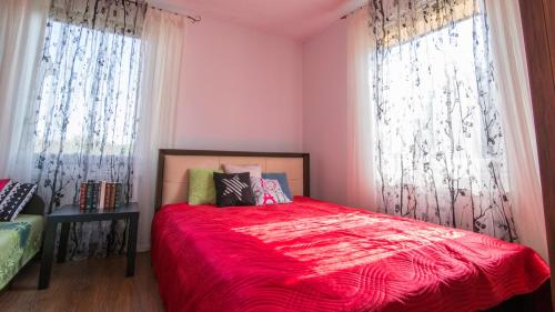 a bedroom with pink walls and a bed with a red blanket at Siedlisko Józefka in Zaróbka