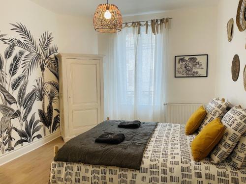 een slaapkamer met een groot bed met gele kussens bij LE MOINET FAYARD in Vichy