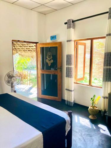 a bedroom with a bed and a large window at Relax point cabana & restaurant in Netolpitiya