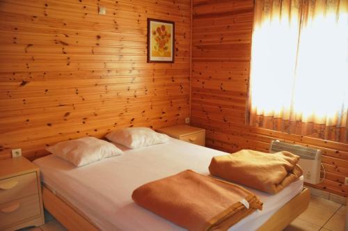 ラ・ロシュ・アン・アルデンヌにあるLes Rochettes Vénus 2の木製の壁にベッド2台が備わるベッドルーム1室