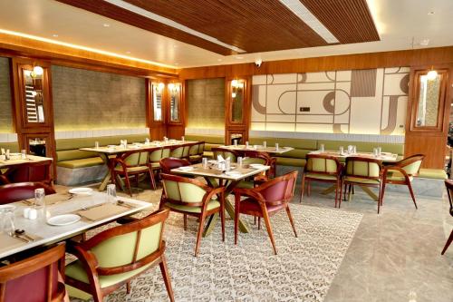 a restaurant with tables and chairs in a room at Hotel HPB Grand in Bhadohī