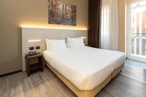 Un dormitorio con una cama blanca grande y una ventana en Garibaldi Palace, en Milán