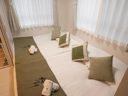 a large bed with pillows on it in a room at 桜の川50 東京晴空塔10分钟本所吾妻橋駅5分钟5人房丨 Tokyo skytree 10 mins Honjo Azumabashi 5 minutes5 people in Tokyo