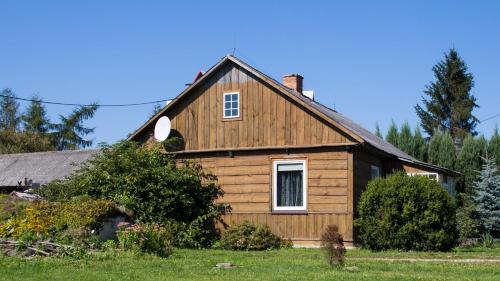 a wooden house with a gambrel roof at Siedlisko Józefka in Zaróbka