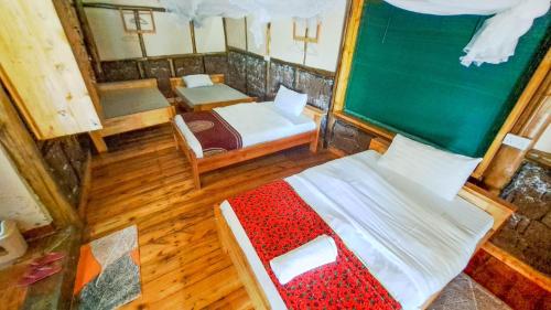einen Blick über ein Schlafzimmer mit 2 Betten und einem Spiegel in der Unterkunft New Casa Gorilla Lodge and Campsite in Kisoro