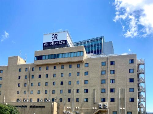 a building with a sign on the top of it at Green Rich Hotel Matsue Ekimae in Matsue