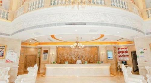 ein großer Raum mit Kronleuchter und Bühne in der Unterkunft Vienna Hotel Anhui Guangde Development Zone in Guangde