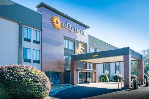 a hotel with a sun sign on the front of it at La Quinta Inn & Suites by Wyndham Fayetteville I-95 in Fayetteville