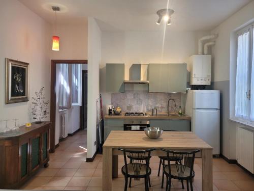 une cuisine avec une table, des chaises et un réfrigérateur dans l'établissement Da Sergio appartamento intero, à Belgioioso